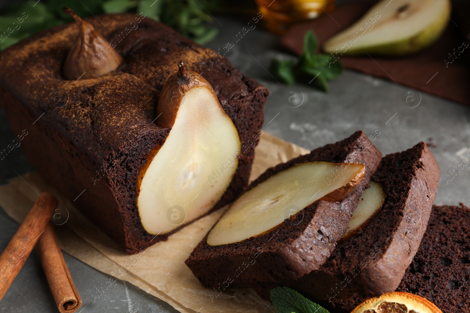 Photo of Tasty pear bread with cinnamon on grey table, closeup. Homemade cake