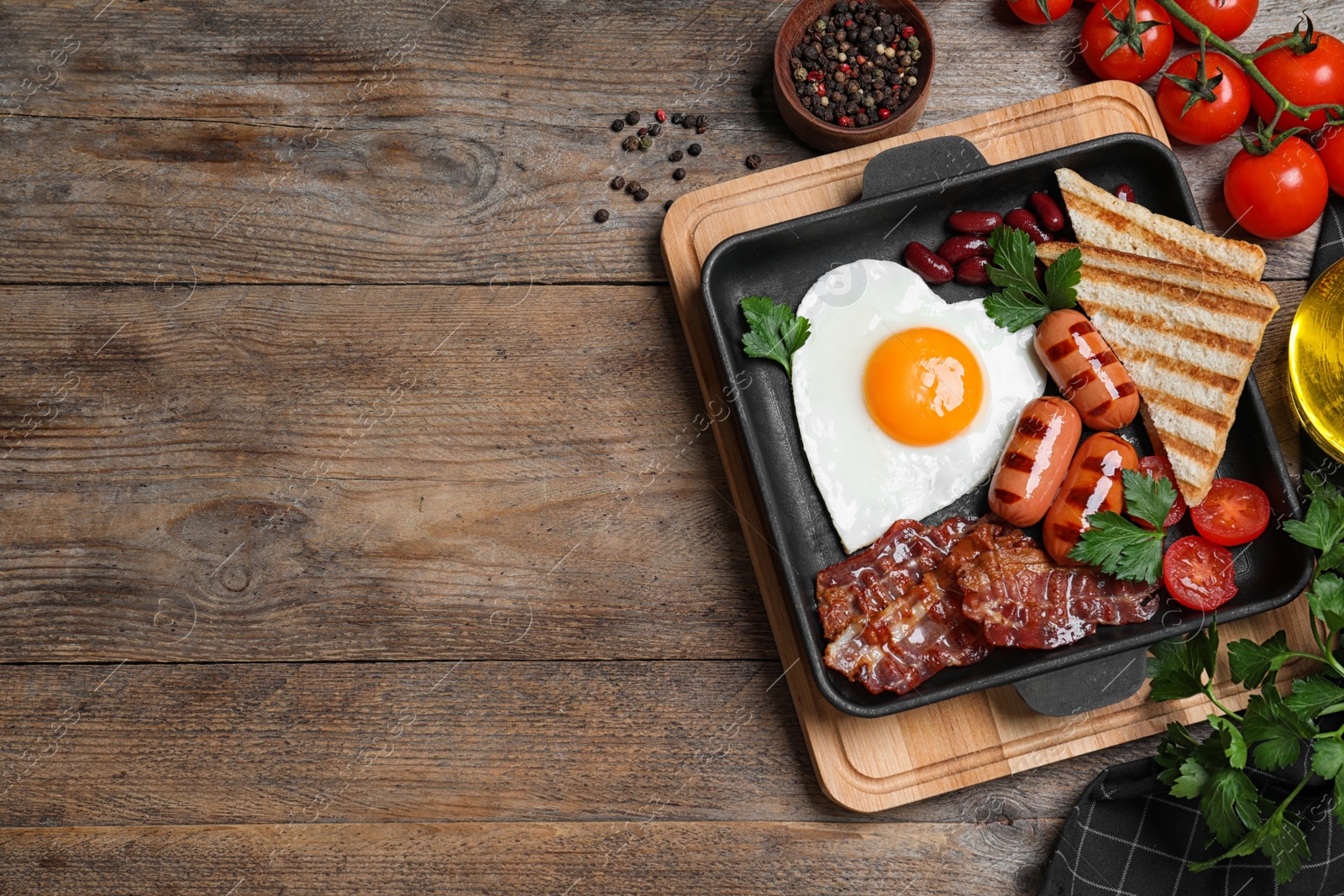 Photo of Delicious breakfast with heart shaped fried egg and  sausages served on wooden table, flat lay. Space for text