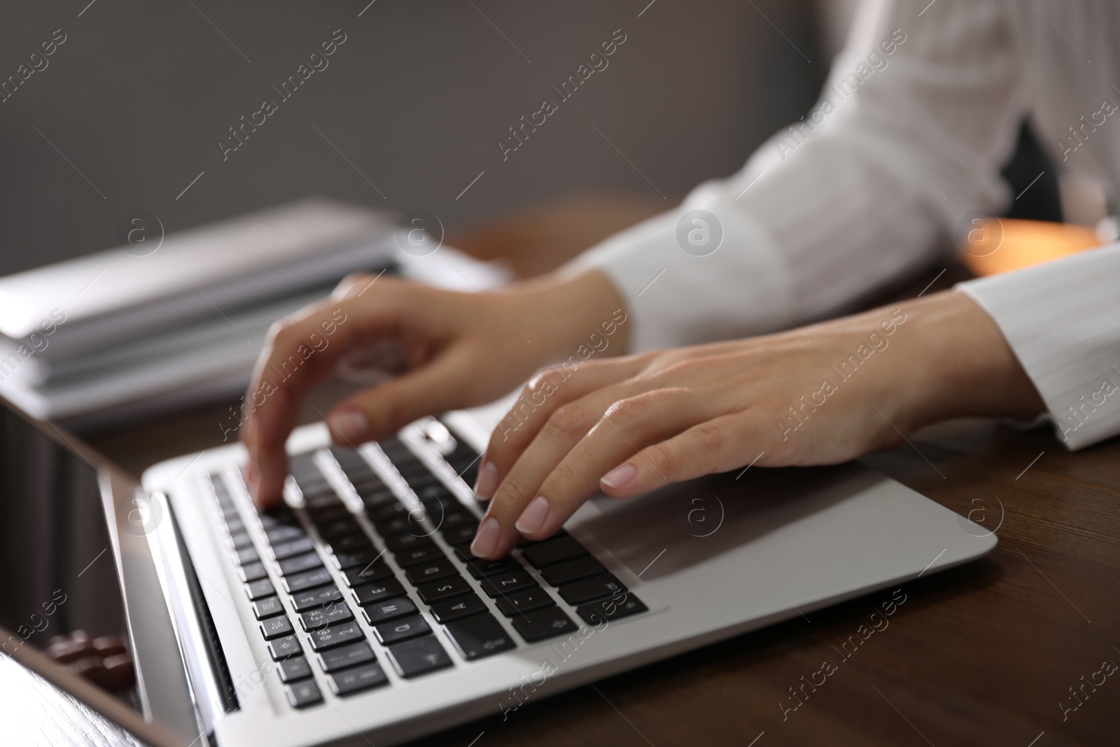 Photo of Woman working with laptop in office, closeup of hands