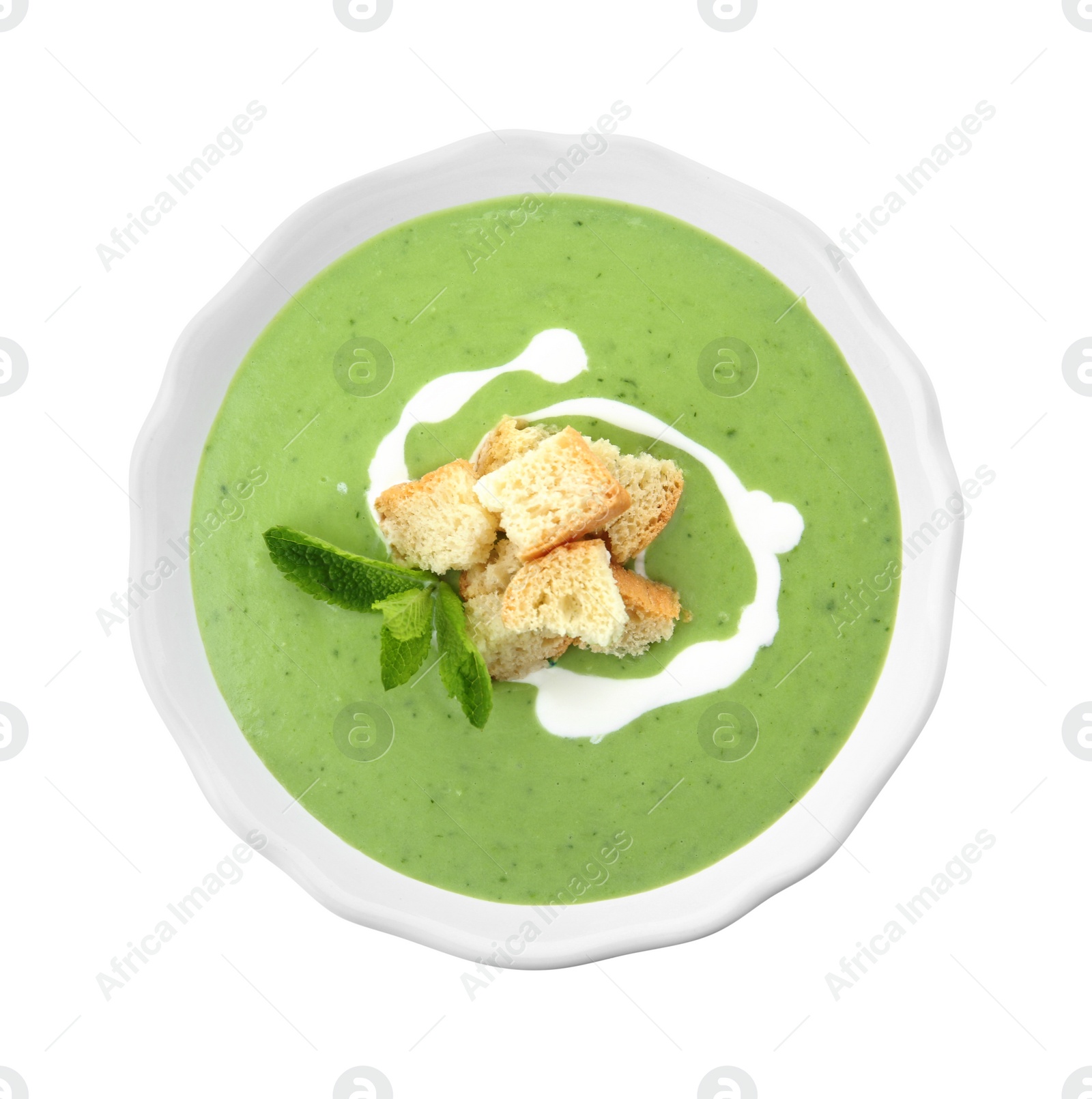 Photo of Green pea soup with croutons in bowl on white background, top view