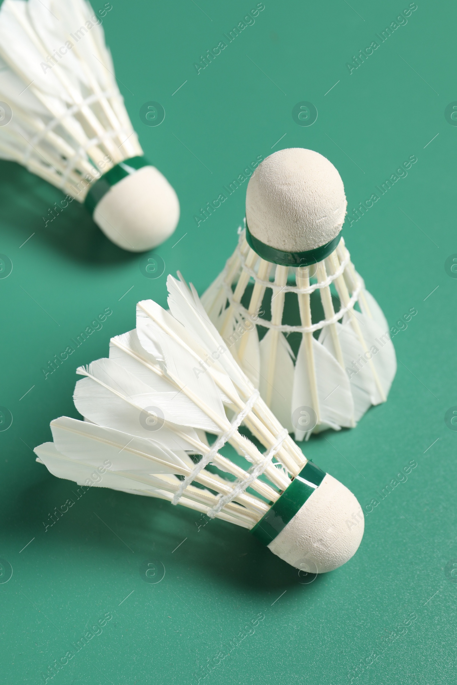 Photo of Feather badminton shuttlecocks on green background, closeup