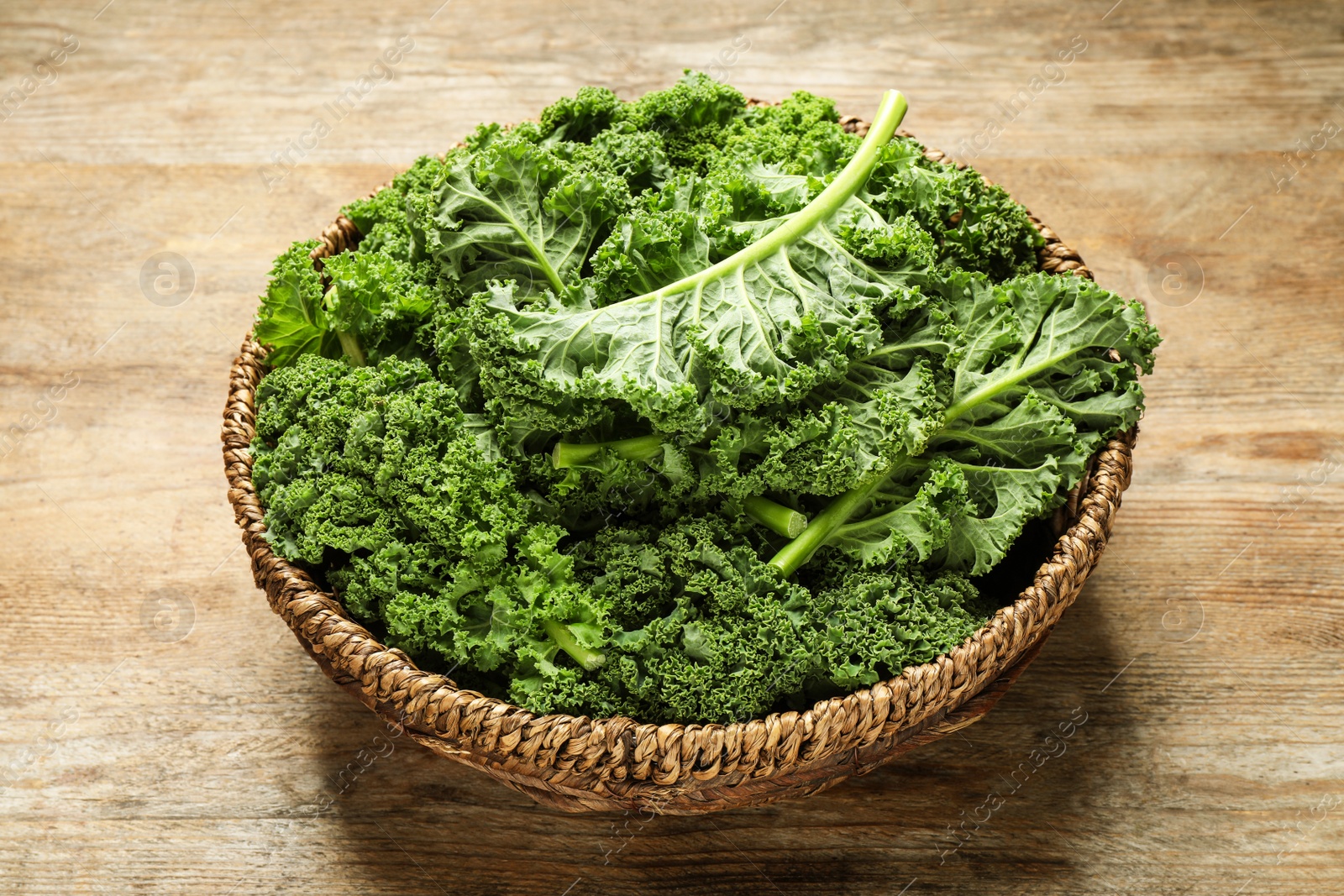 Photo of Fresh green kale leaves on wooden table