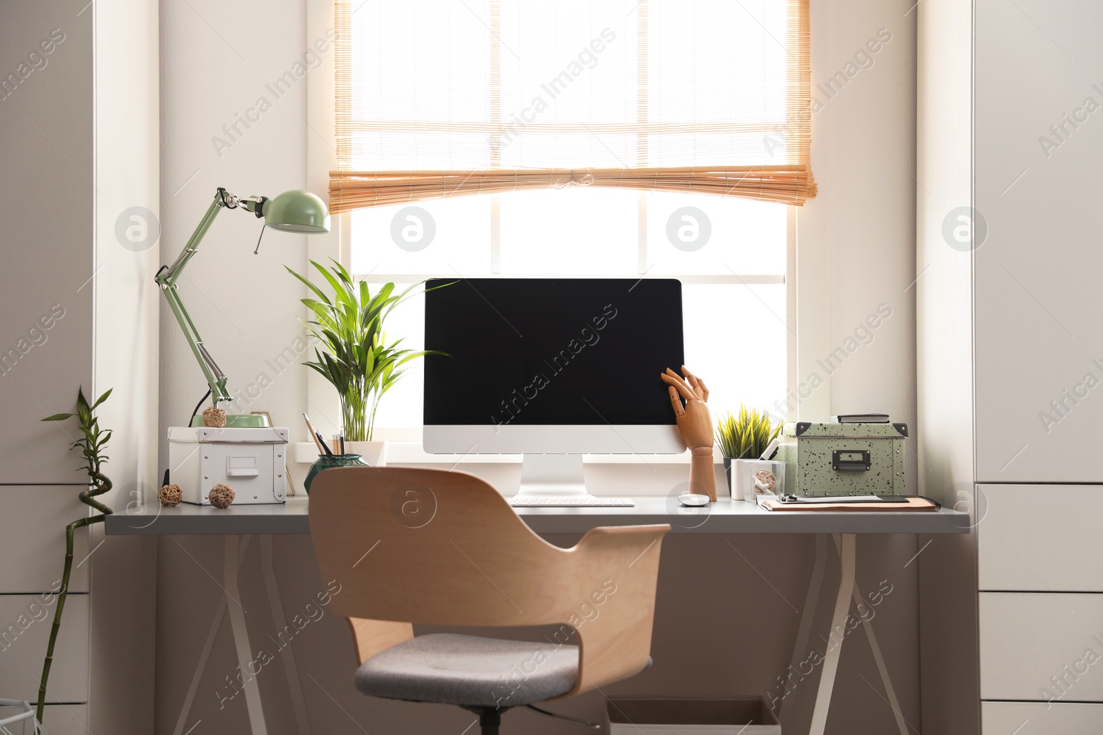 Photo of Light work place with computer near window at home. Interior design