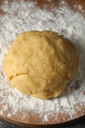 Photo of Making shortcrust pastry. Raw dough and flour on table, above view
