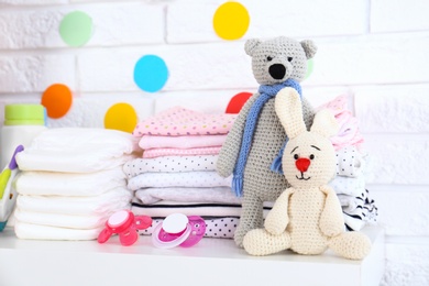 Baby accessories on shelf near white brick wall