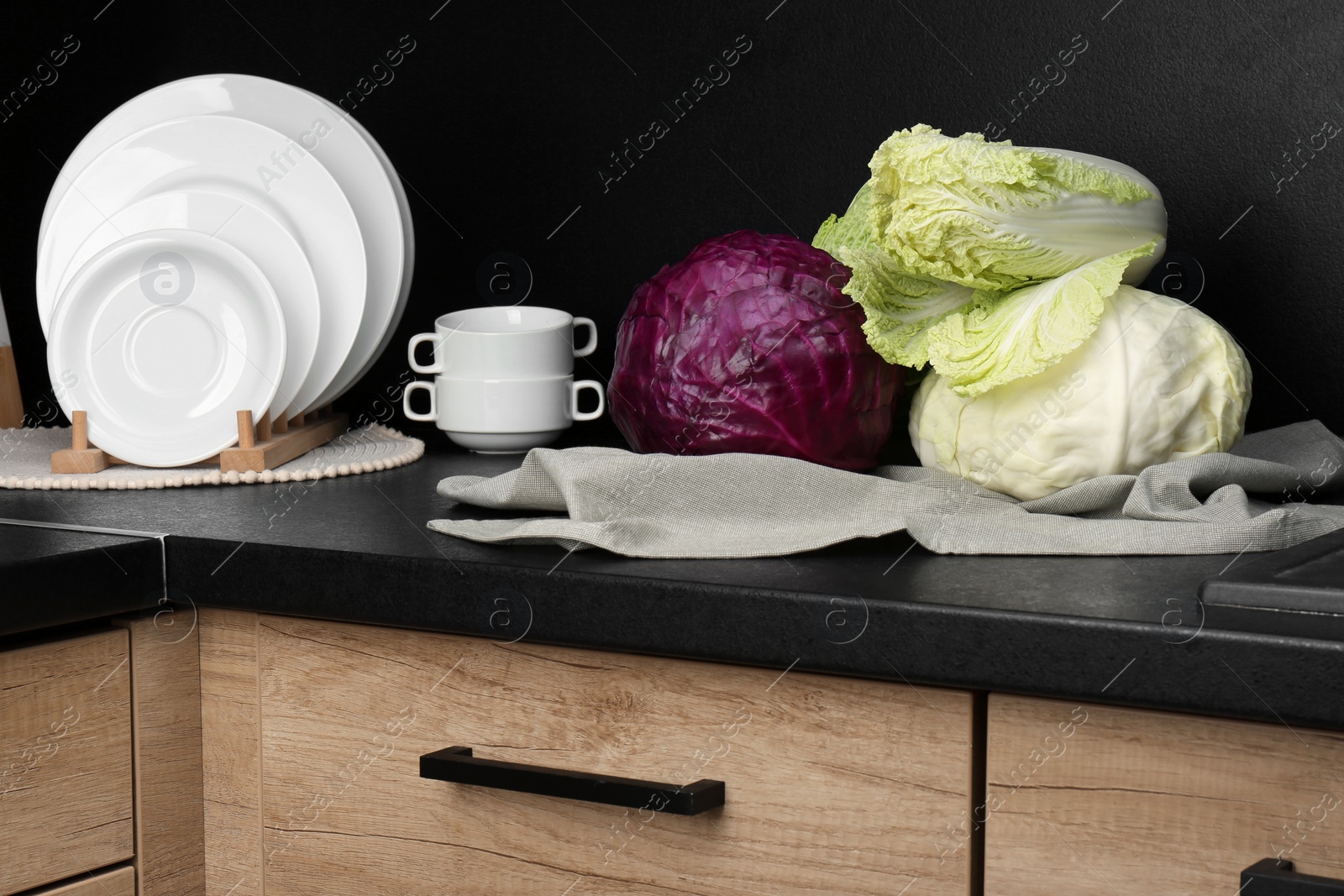 Photo of Different types of cabbage on countertop in kitchen