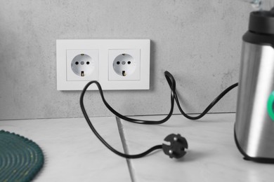 Photo of Power sockets and blender on white table