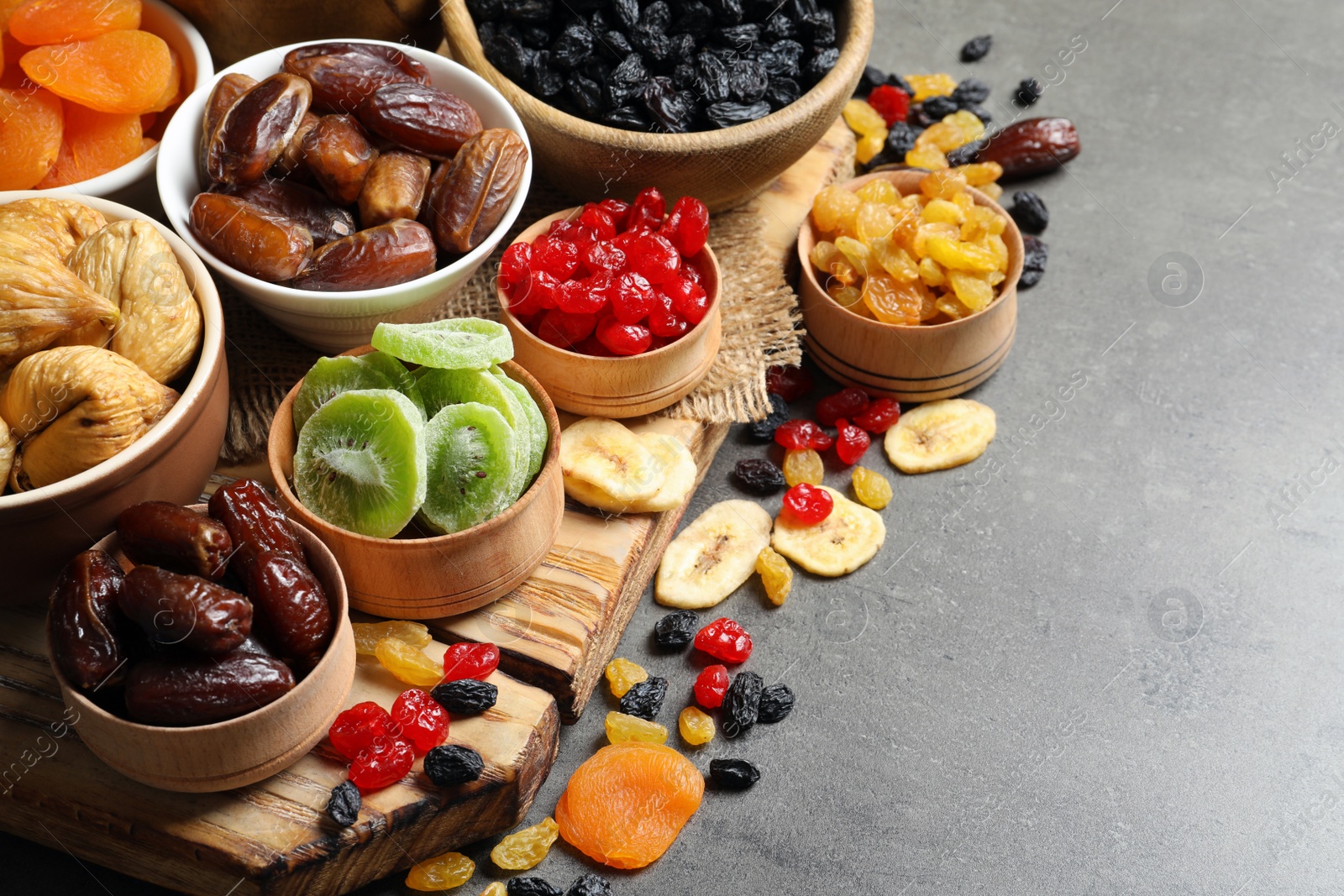 Photo of Bowls with different dried fruits on table, space for text. Healthy food