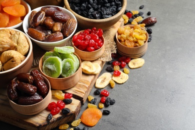Photo of Bowls with different dried fruits on table, space for text. Healthy food
