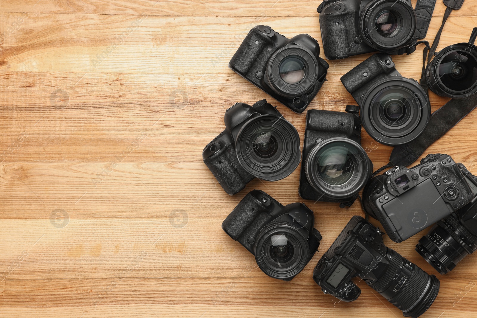 Photo of Modern different cameras on wooden table, flat lay. Space for text