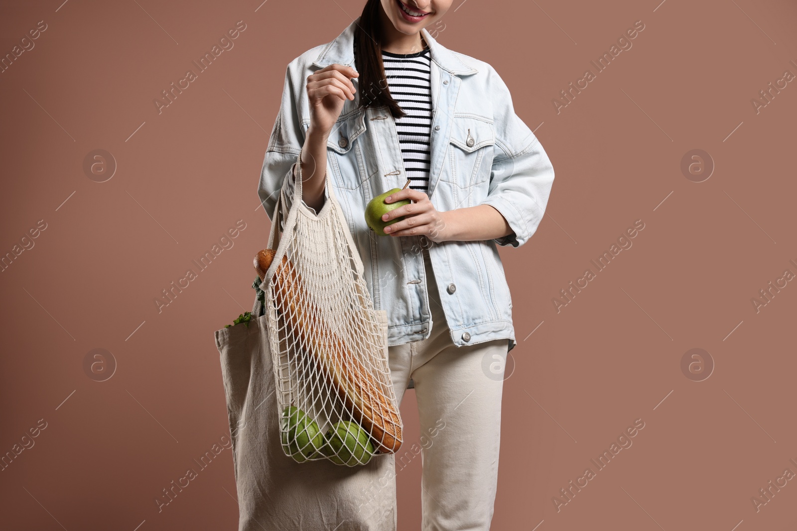 Photo of Woman with eco bags full of products on pink background