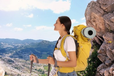 Woman with backpack and trekking poles on sunny day