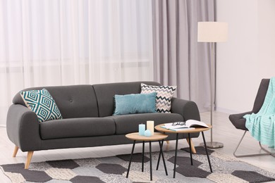 Photo of Comfortable sofa, armchair and coffee table in stylish living room. Interior design