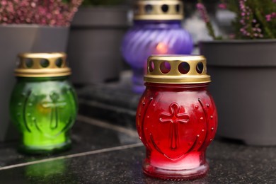 Photo of Different grave lanterns on granite surface at cemetery