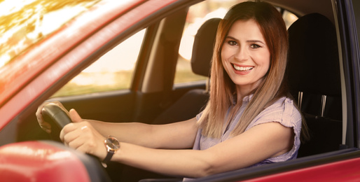 Image of Happy woman driving modern car on sunny day