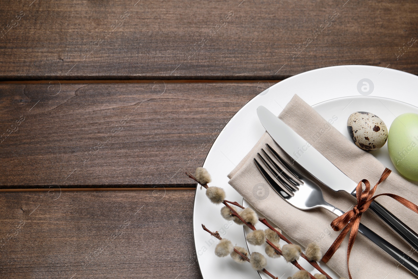 Photo of Festive Easter table setting with eggs on wooden background, top view. Space for text