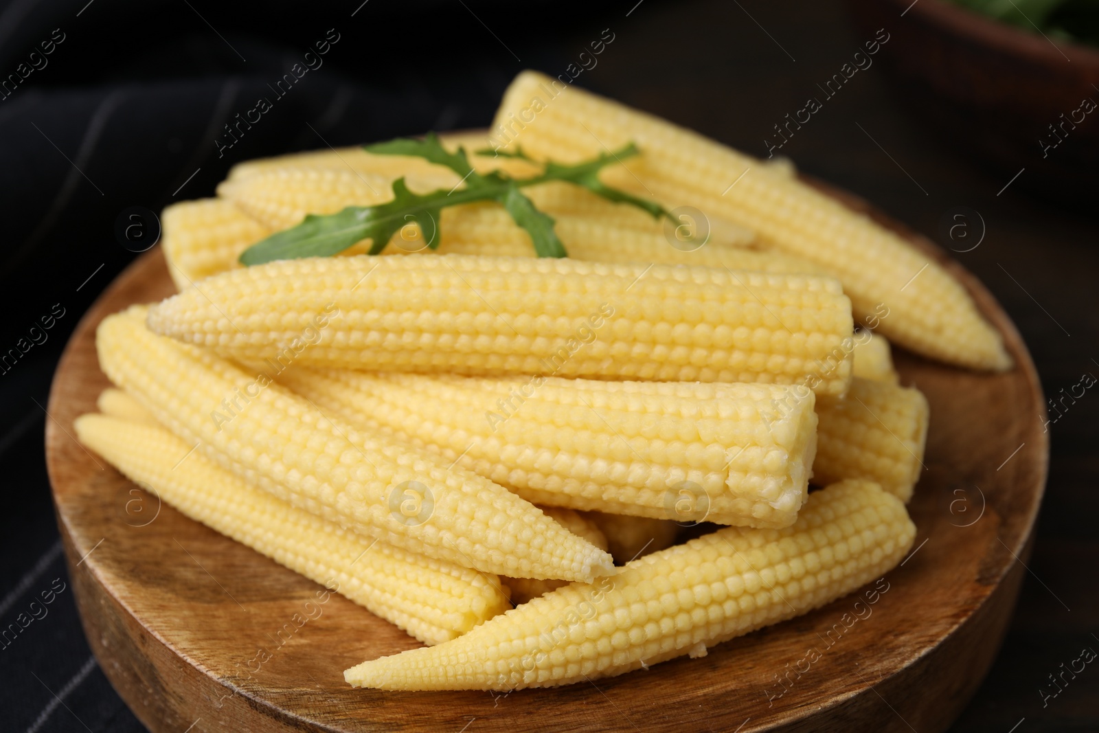 Photo of Tasty fresh yellow baby corns on wooden table, closeup