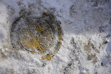 Sewer hatch covered with snow outdoors, top view