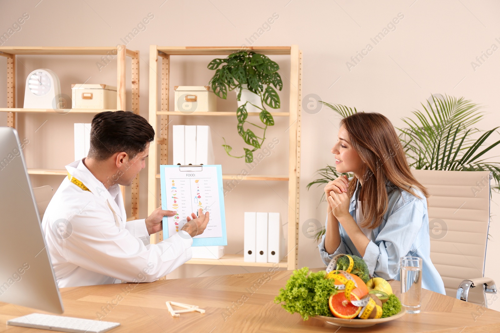 Photo of Nutritionist consulting patient at table in clinic