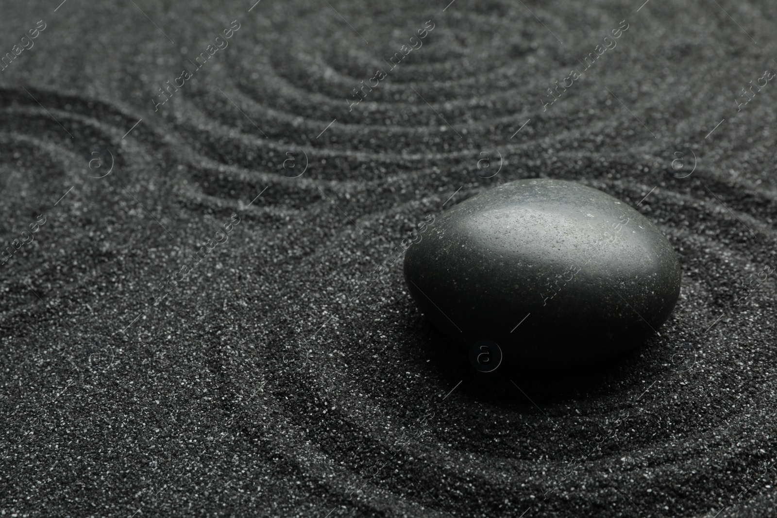 Photo of Black sand with stone and beautiful pattern. Zen concept