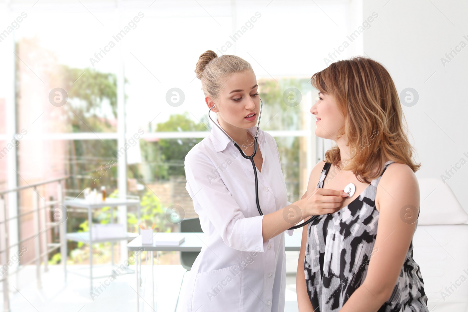 Photo of Doctor examining patient with stethoscope in hospital