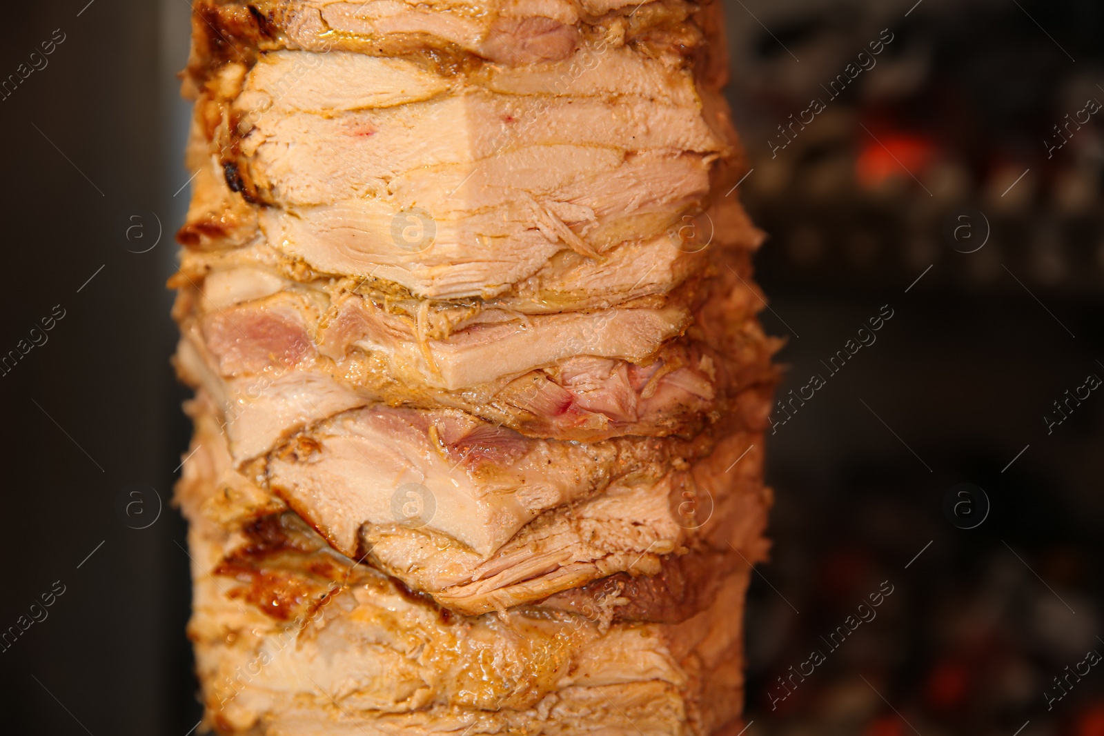 Photo of Vertical rotisserie with roasted meat, closeup view