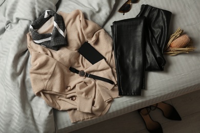 Photo of Stylish look with cashmere sweater, flat lay. Women's clothes and accessories on bed