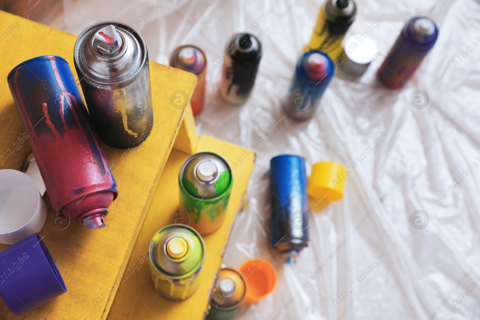 Photo of Used cans of spray paints indoors, above view. Graffiti supplies