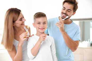 Photo of Happy family with toothbrushes in bathroom. Personal hygiene