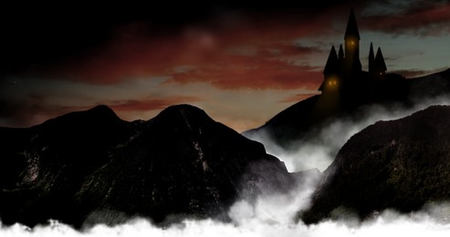 Fantasy world. Mystical castle and mountains covering with fog in night