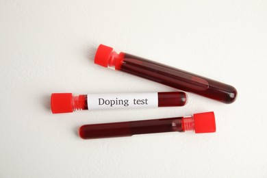 Test tubes with blood samples on beige background, flat lay. Doping control