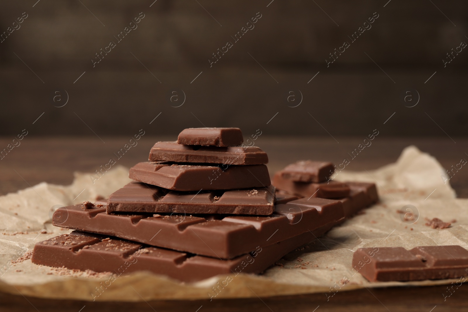 Photo of Pieces and crumbs of tasty chocolate bars on table, closeup