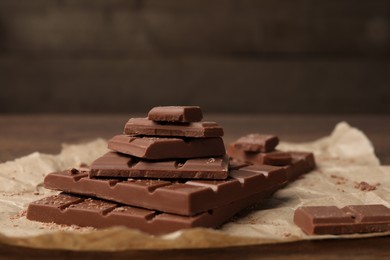 Pieces and crumbs of tasty chocolate bars on table, closeup
