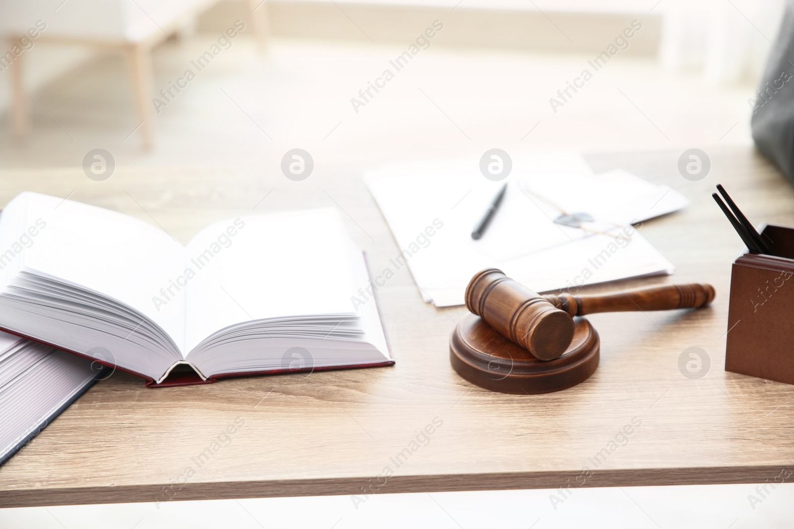 Photo of Open book and judge gavel on table. Law and justice concept