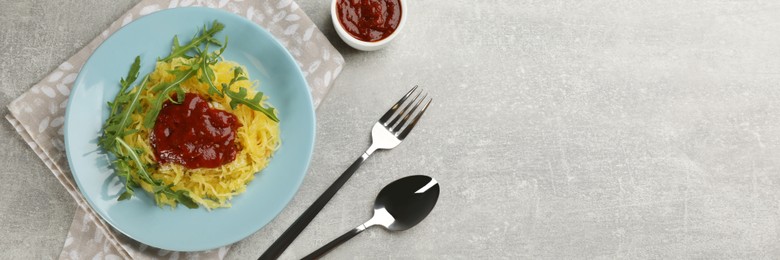 Image of Tasty spaghetti squash with tomato sauce and arugula served on grey table, flat lay. Banner design with space for text