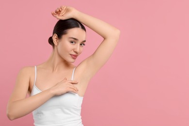 Photo of Beautiful woman showing armpit with smooth clean skin on pink background, space for text