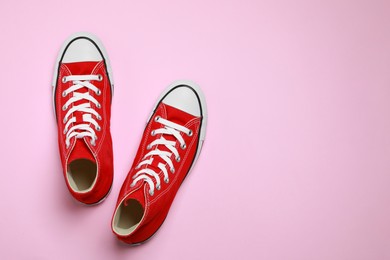 Photo of Pair of new stylish red sneakers on pink background, flat lay. Space for text