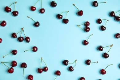 Flat lay composition with sweet red cherries on color background