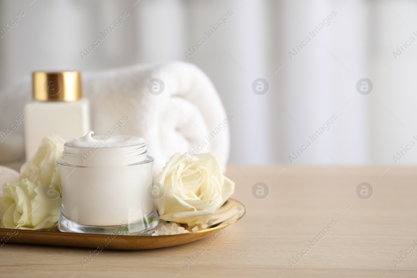 Photo of Spa composition with skin care products and flowers on wooden table. Space for text