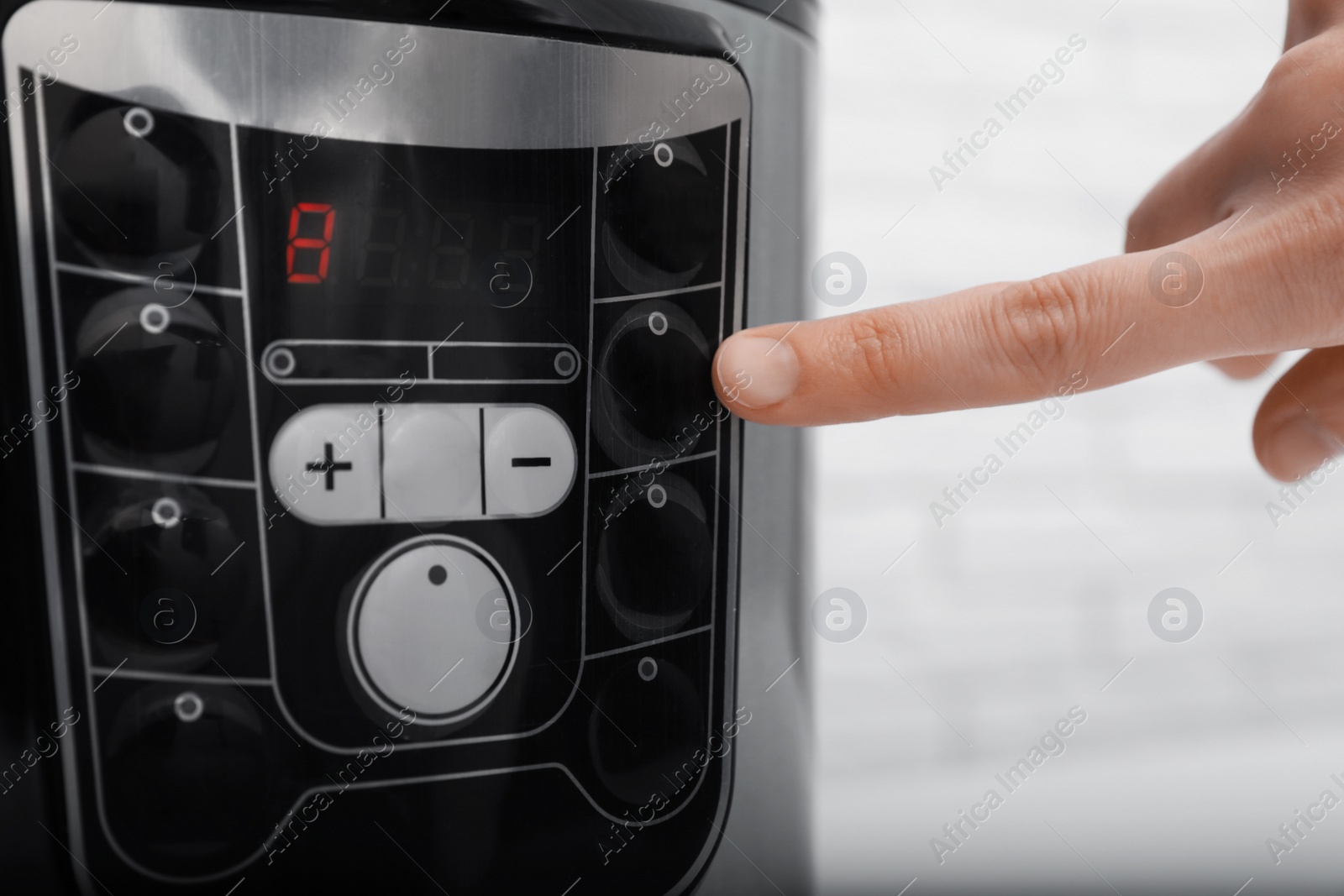 Photo of Woman turning on modern electric multi cooker, closeup