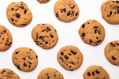 Photo of Many delicious chocolate chip cookies on white background, flat lay