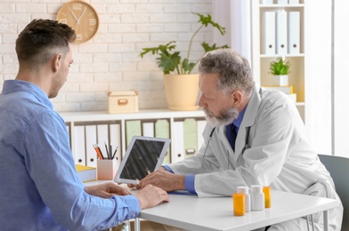 Photo of Mature doctor consulting patient in clinic