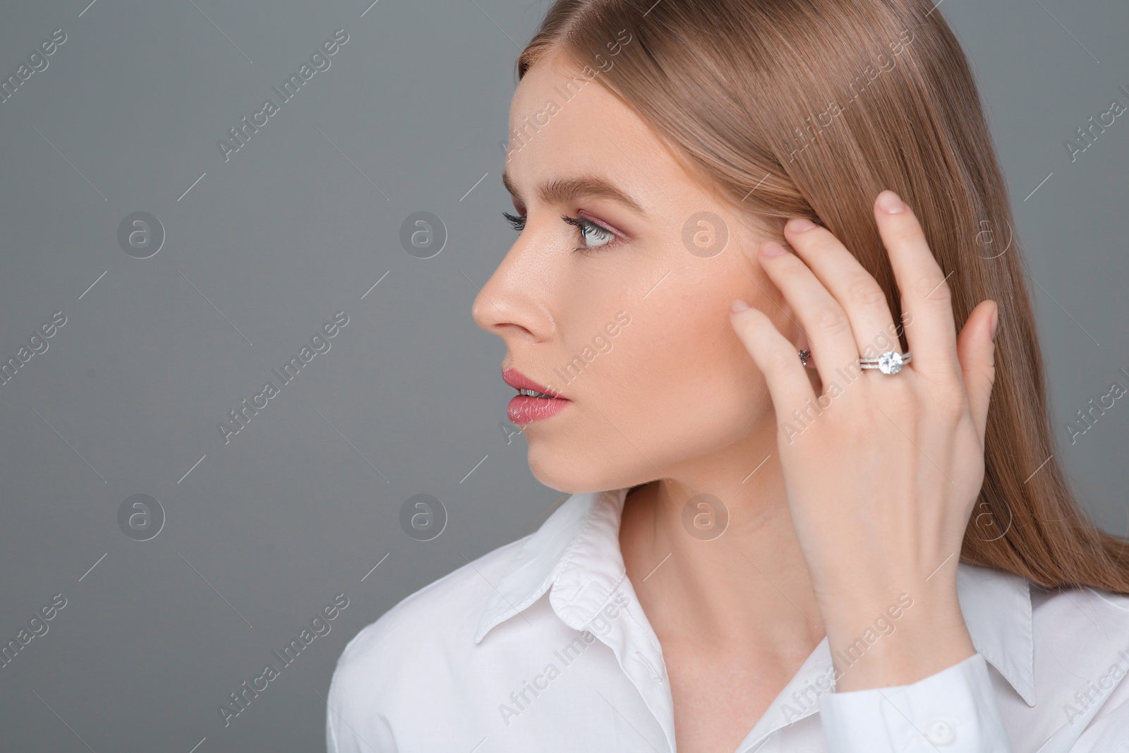 Photo of Beautiful young woman with elegant ring on gray background, space for text
