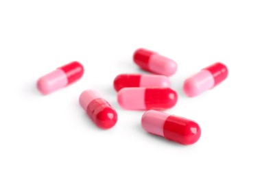 Photo of Many pink pills isolated on white. Medicinal treatment