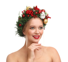 Beautiful young woman wearing Christmas wreath on white background