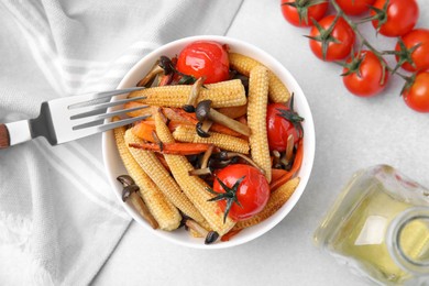 Tasty roasted baby corn with tomatoes and mushrooms served on white table, flat lay