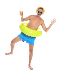 Photo of Shirtless man with inflatable ring and bottle of drink having fun on white background