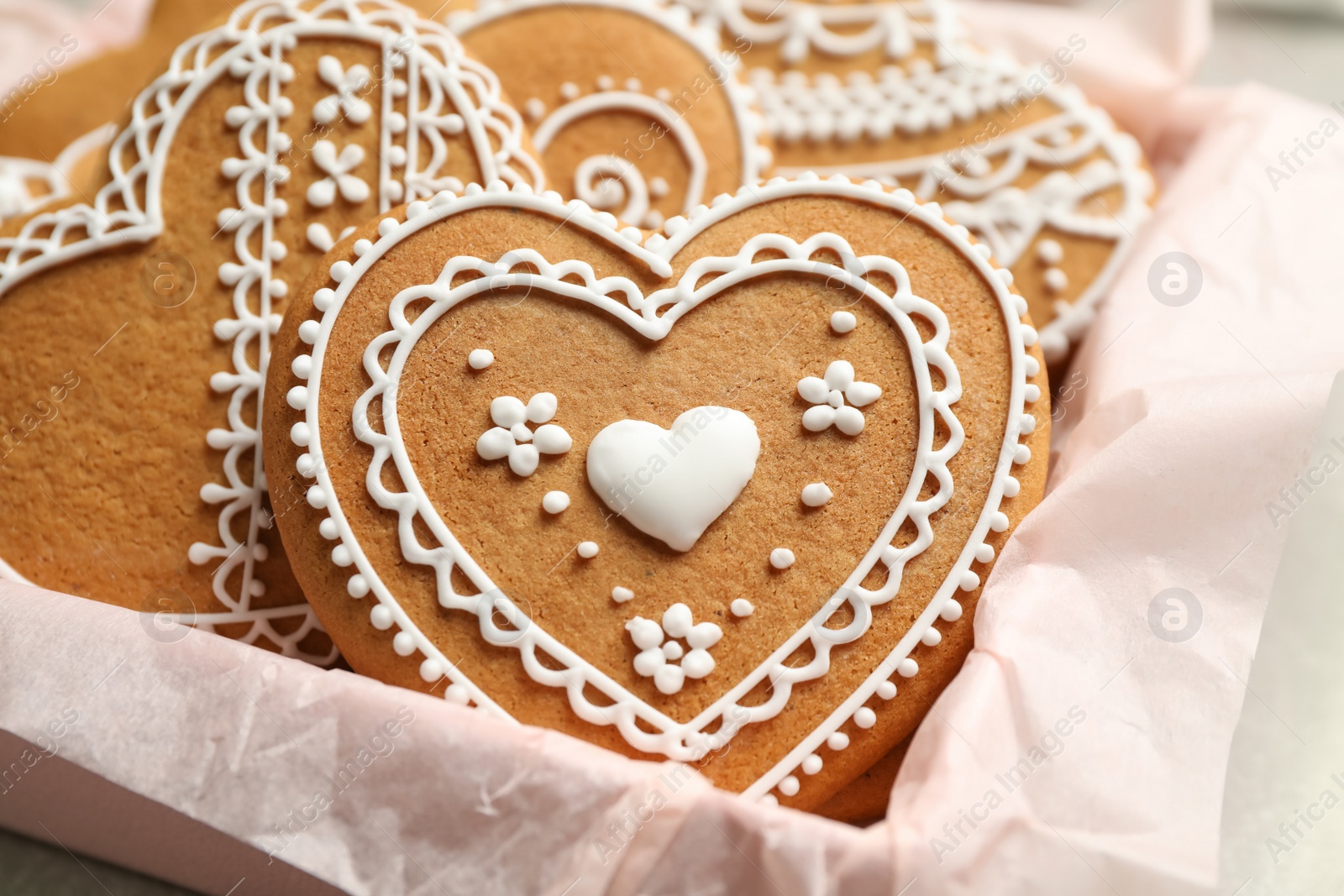 Photo of Tasty heart shaped gingerbread cookies in box, closeup