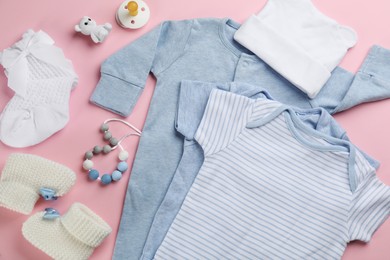 Flat lay composition with baby clothes and accessories pink background