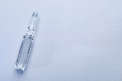 Photo of Pharmaceutical ampoule with medication on white background, top view. Space for text